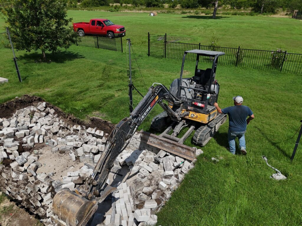 Excavator removing concrete and debris for site demolition project